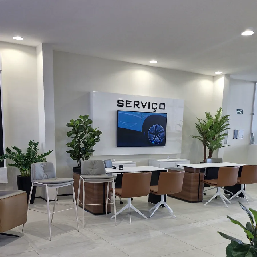 Área de Serviço da concessionária, com balcão de atendimento e mesas de consultoria